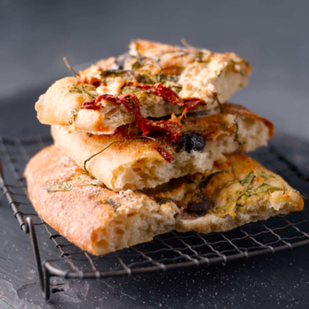 Nybagt focaccia med tomat og oliven på rist