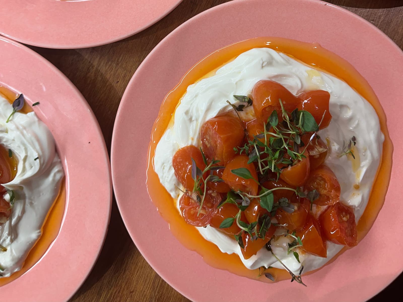 Yoghurt med bagte tomater på lyserøde tallerkener